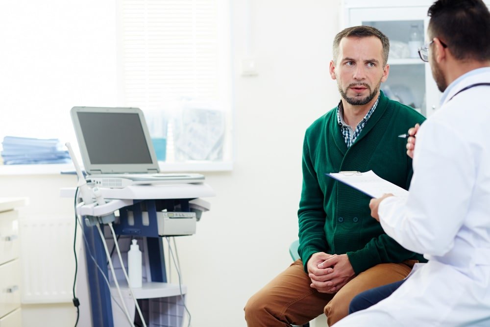 Photo showing a healthcare professional reviewing medical information with a patient during an in office visit. Image used by a medical clinic in San Bernardino to represent personalized care patient communication and primary healthcare services
