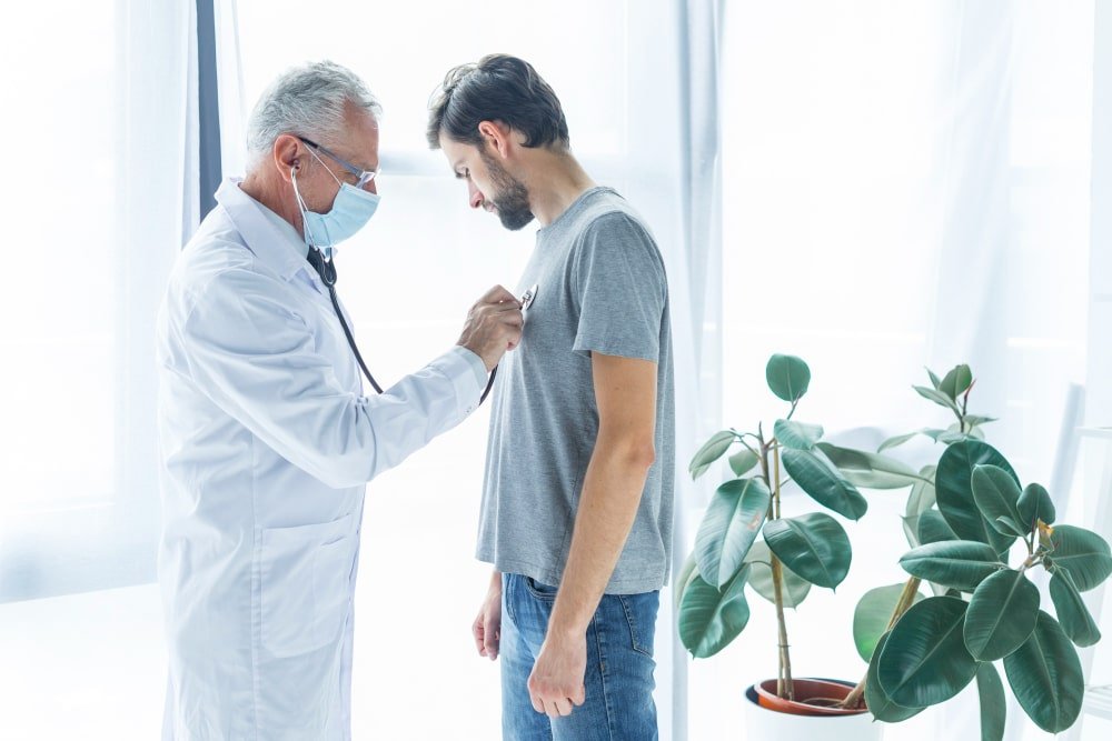 Photo showing a healthcare provider speaking with a patient during a medical appointment in a modern clinical setting. Image used by a medical clinic in San Bernardino to represent patient centered care medical consultations and primary healthcare services