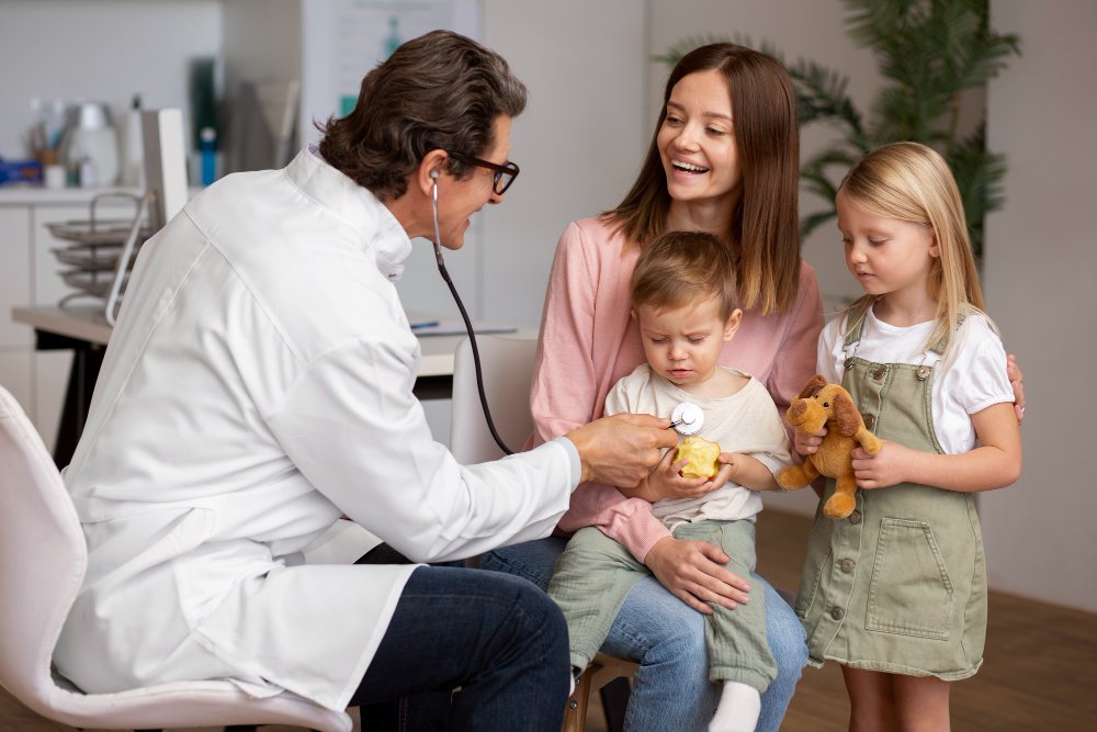 Photo of a family meeting with a healthcare provider during a routine check up in a clinical setting. Image used by a medical clinic in San Bernardino to represent family focused primary care.