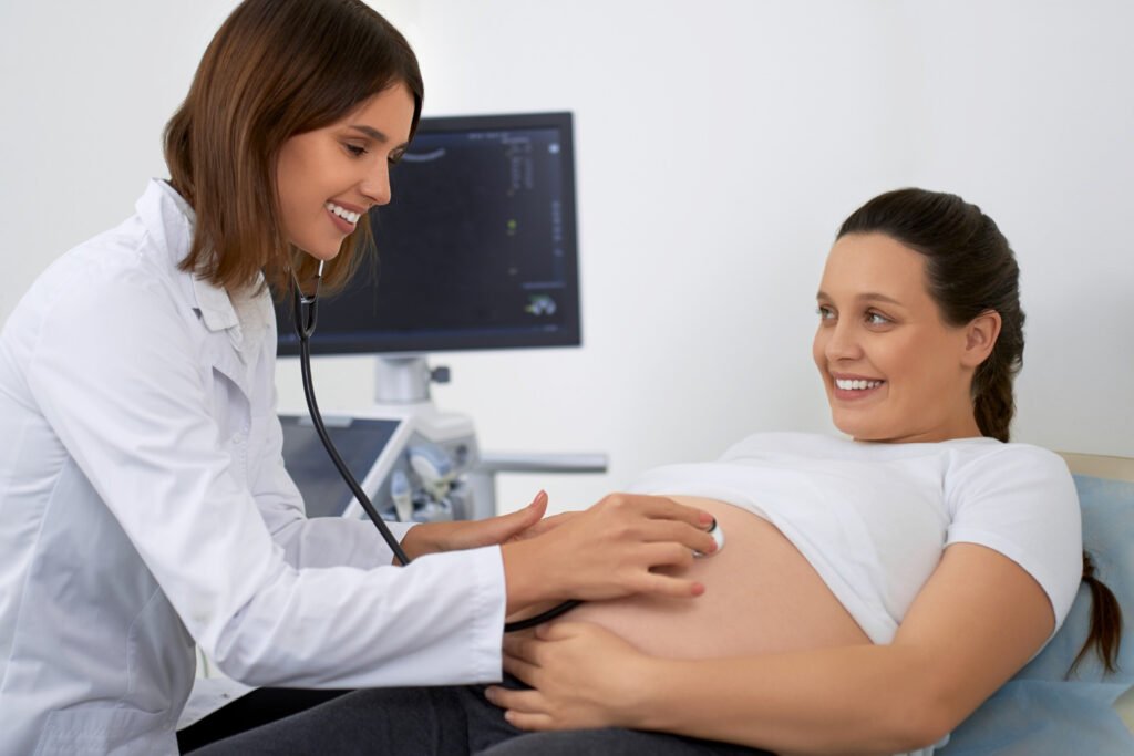 Photo of a healthcare provider performing a pregnancy check up by examining a pregnant patient in a clinical setting. Image used by a medical clinic in San Bernardino to represent prenatal care.