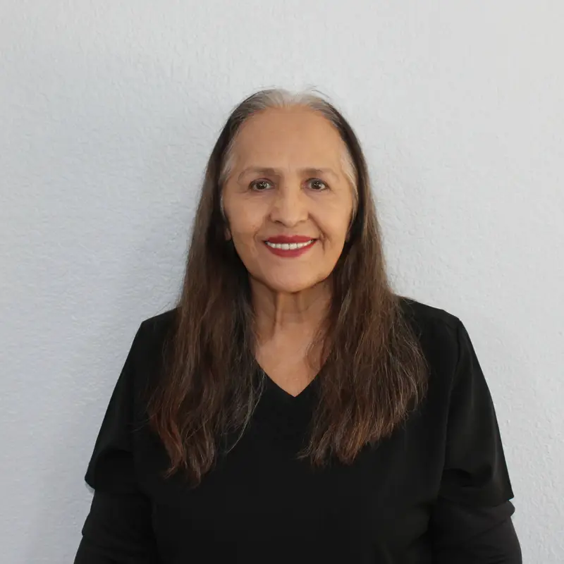 Photo of a female healthcare professional smiling in a clinical or professional setting. Image used by a medical clinic in San Bernardino to represent medical staff and patient care.
