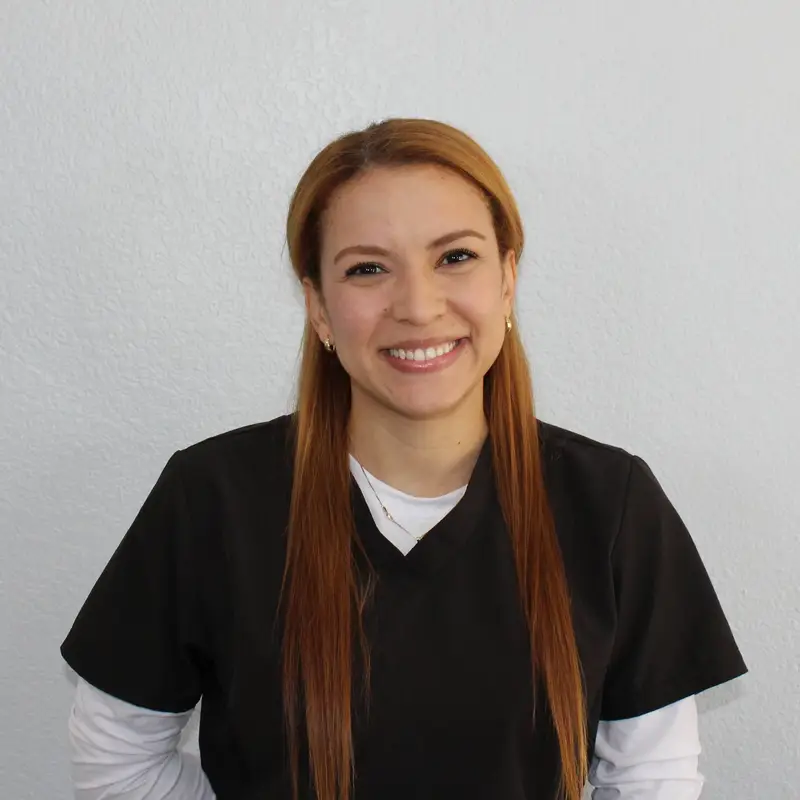 Photo of a female healthcare professional smiling in a professional setting. Image used by a medical clinic in San Bernardino to represent clinic staff and patient care.